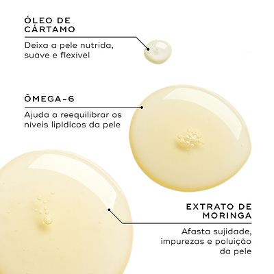 Close-up de gotas de óleo dourado num fundo branco. Linhas de texto destacam os ingredientes-chave: Óleo de Cártamo para deixar a pele nutrida, suave e flexível; Ómega-6 para ajudar a reequilibrar os níveis lipídicos da pele; e Extrato de Moringa para afastar sujidade, impurezas e poluição da pele.