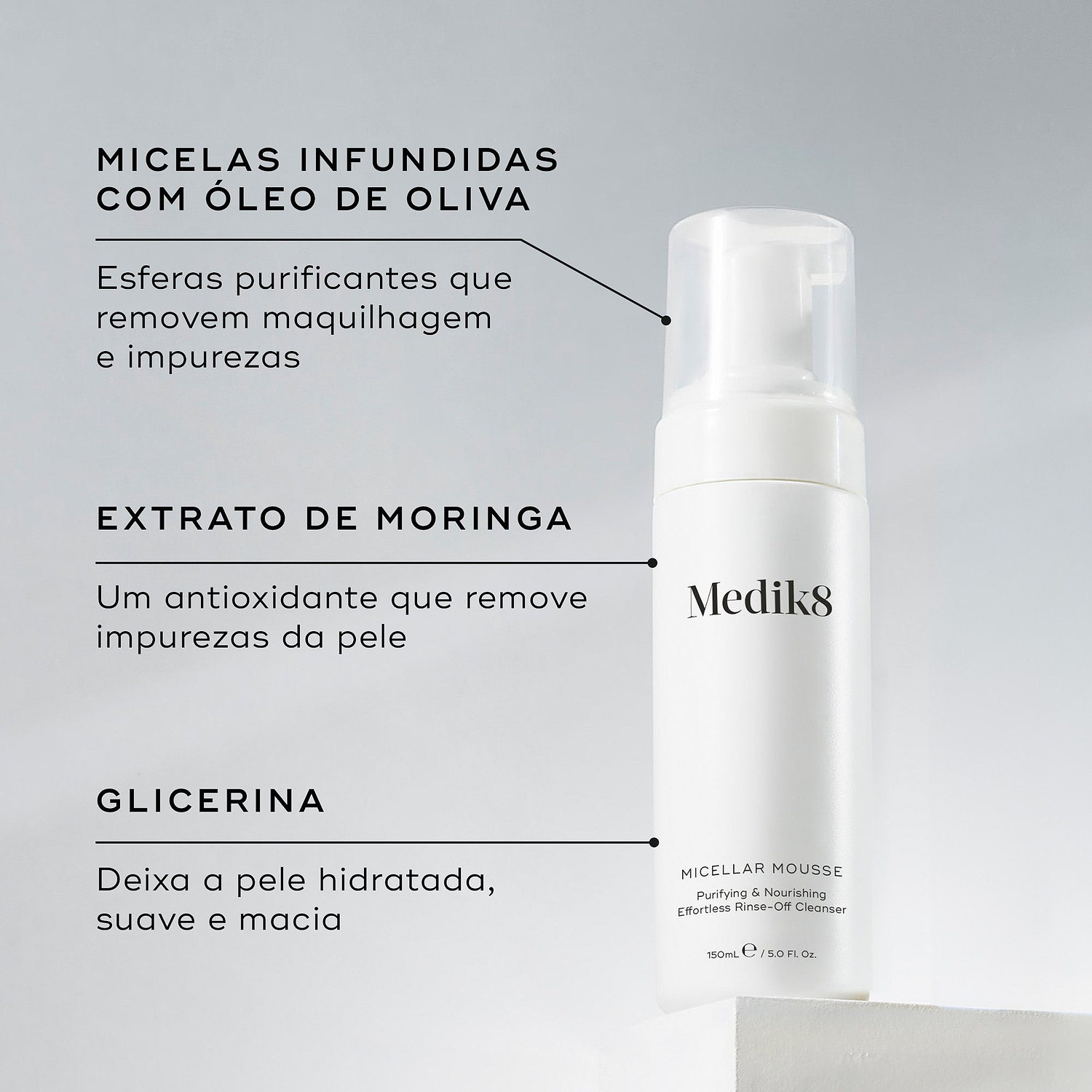 O frasco doseador Micellar Mousse assenta num pedestal branco contra um fundo cinza claro. Linhas de texto destacam os ingredientes-chave: Micelas Infundidas com Óleo de Oliva para remover maquilhagem e impurezas, Extrato de Moringa para remover impurezas da pele, e Glicerina para deixar a pele hidratada e macia.