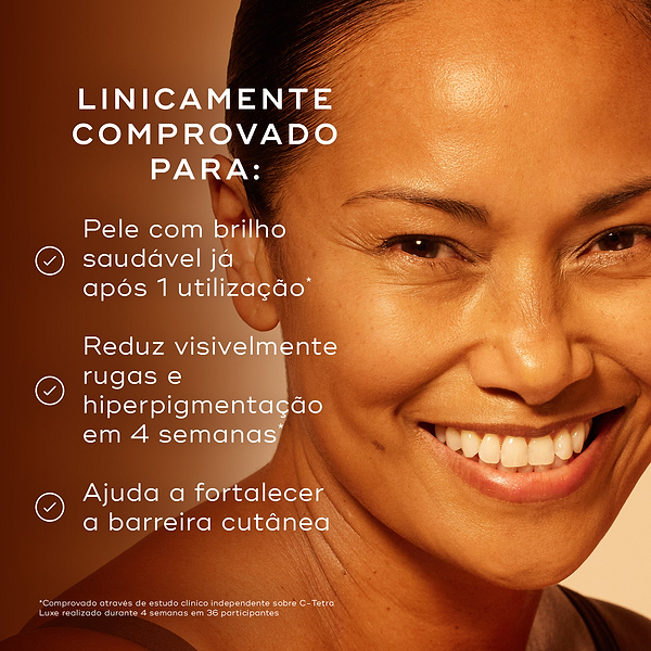 Close-up de uma mulher sorridente com pele luminosa contra um fundo quente. Os marcadores afirmam que é clinicamente comprovado para proporcionar um brilho saudável após 1 utilização, reduzir visivelmente rugas e hiperpigmentação em 4 semanas, e ajudar a fortalecer a barreira cutânea.