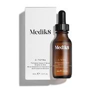 Frasco de vidro âmbar do sérum Medik8 C-Tetra Lipid Vitamin C Radiance Serum apresentado ao lado da sua embalagem de cartão branca. Ambos estão sobre um fundo branco limpo, com uma sombra subtil.