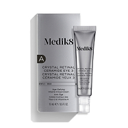 Uma bisnaga prateada do Medik8 Crystal Retinal Ceramide Eye 3 está colocada ao lado da sua embalagem prateada correspondente.