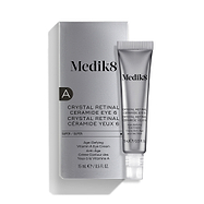 Uma bisnaga prateada do Medik8 Crystal Retinal Ceramide Eye 6 está colocada ao lado da sua embalagem prateada correspondente.