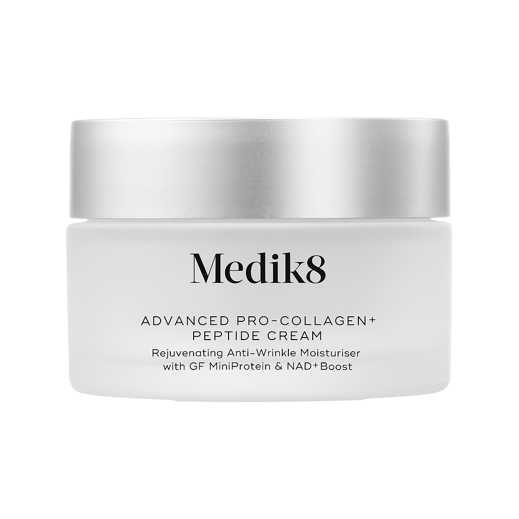 O frasco do creme Medik8 Advanced Pro-Collagen+ Peptide Cream está centralizado sobre um fundo branco liso. O frasco é de vidro jateado com uma tampa prateada. O texto no frasco o identifica como um hidratante rejuvenescedor antirrugas com GF MiniProtein e NAD+ Boost.