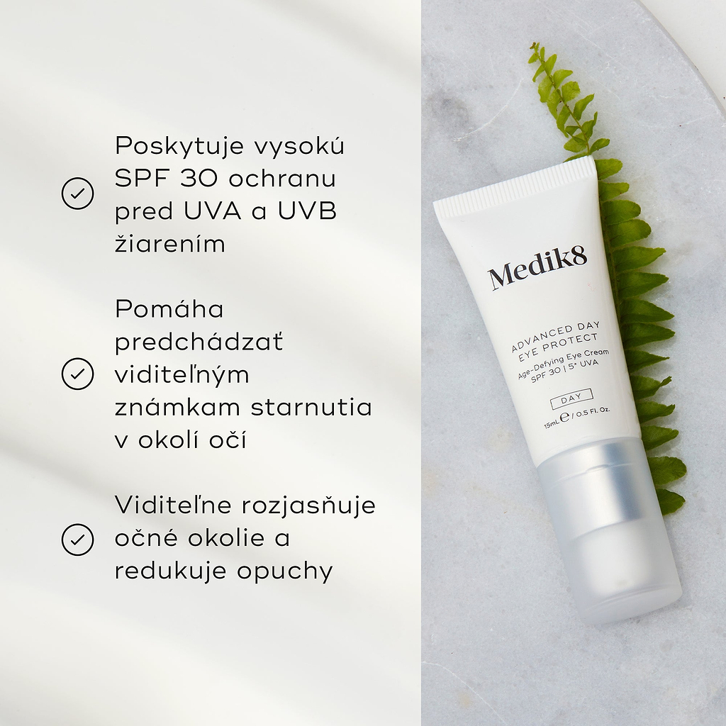 Tuba krému Advanced Day Eye Protect leží na mramorovom povrchu vedľa zeleného listu paprade. Text zdôrazňuje ochranu SPF 30, prevenciu viditeľných známok starnutia a schopnosť rozjasniť očné okolie a zmierniť opuchy.
