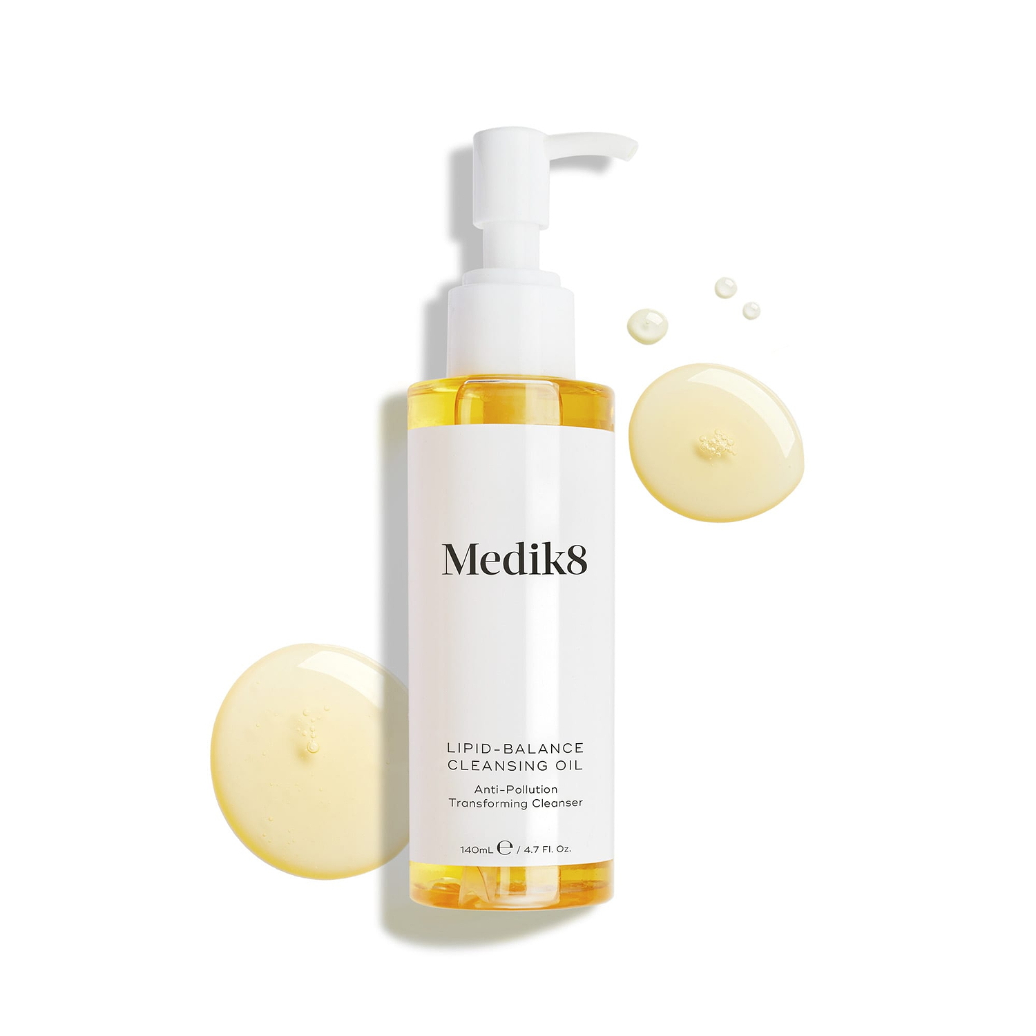 Medik8 Lipid-Balance Cleansing Oil bottle stands against a white background. Golden oil droplets surround the bottle, highlighting its rich, fluid texture.