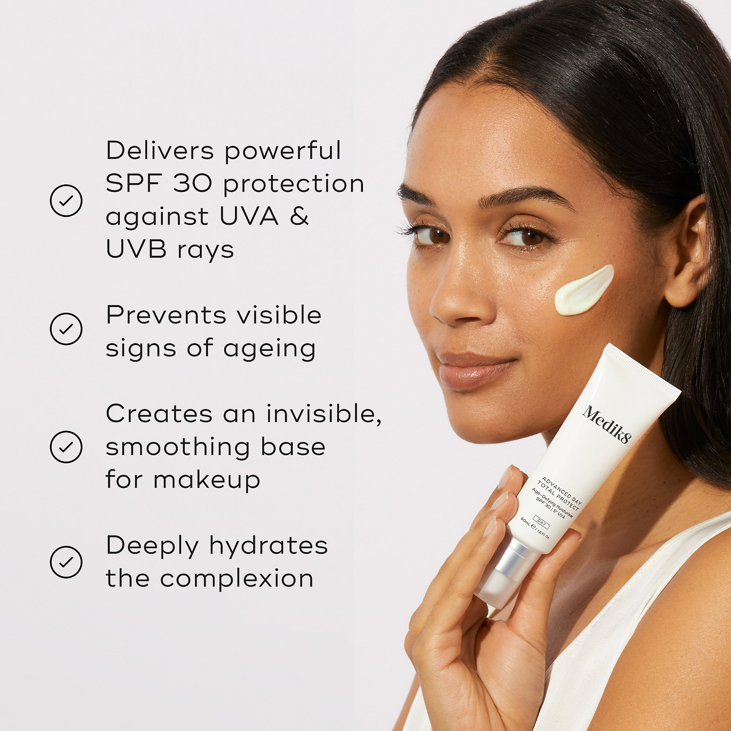A model holding the Medik8 Advanced Day Total Protect tube next to a list of benefits with checkmark icons. Text highlights that it delivers powerful SPF 30 protection against UVA and UVB rays, prevents visible signs of ageing, creates an invisible smoothing base for makeup, and deeply hydrates the complexion.
