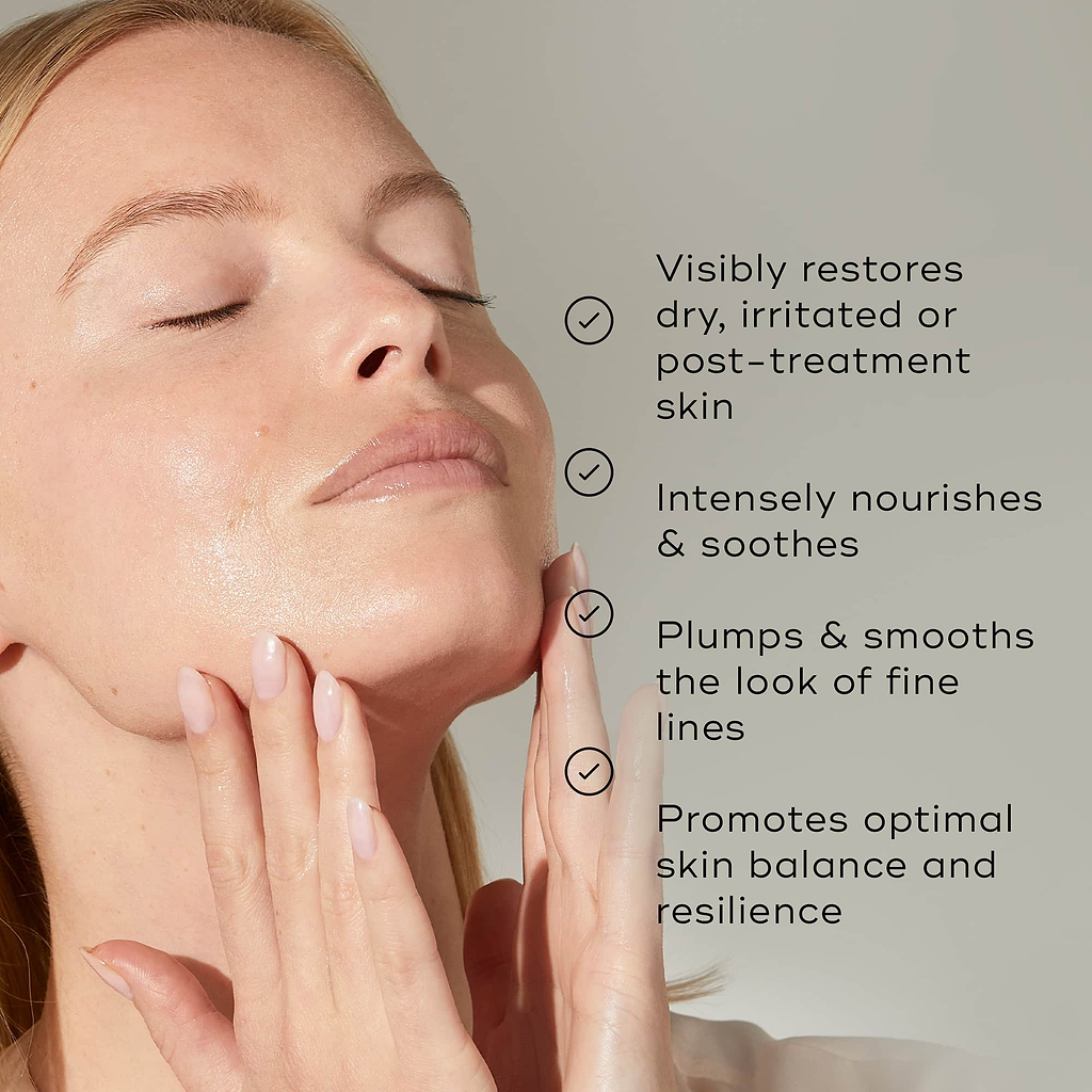 Close-up of a person with glowing, hydrated skin gently touching their jawline with eyes closed against a light grey background. Text highlights key benefits with checkmarks: "Visibly restores dry, irritated or post-treatment skin," "Intensely nourishes & soothes," "Plumps & smooths the look of fine lines," and "Promotes optimal skin balance and resilience."