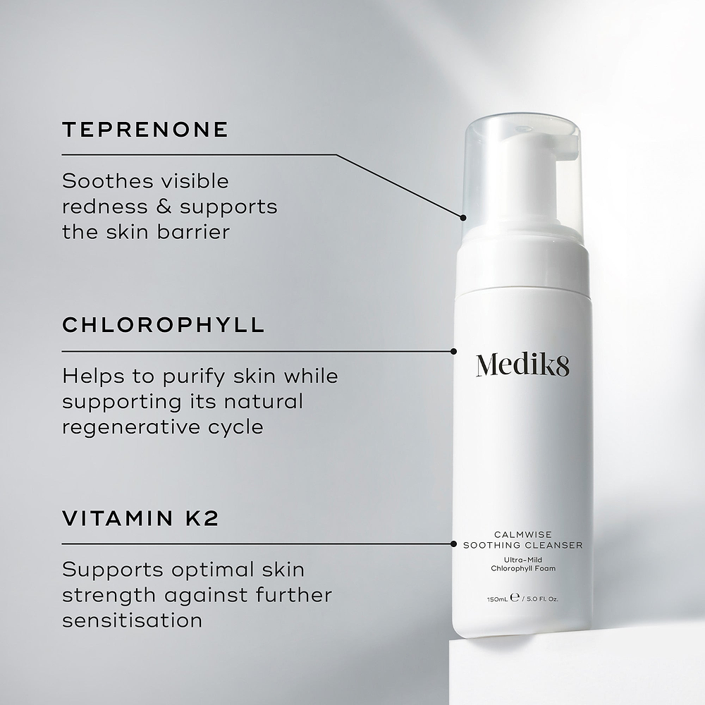 A Medik8 Calmwise Soothing Cleanser bottle displayed on a white block. Lines connect the bottle to text explaining key ingredients: "Teprenone" to soothe redness, "Chlorophyll" to purify skin, and "Vitamin K2" to support skin strength.