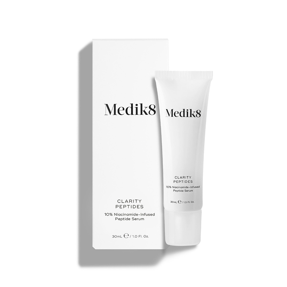 Medik8 Clarity Peptides tube stands next to its white packaging carton on a white background. Text identifies it as a "10% Niacinamide-Infused Peptide Serum" in a 30mL size.