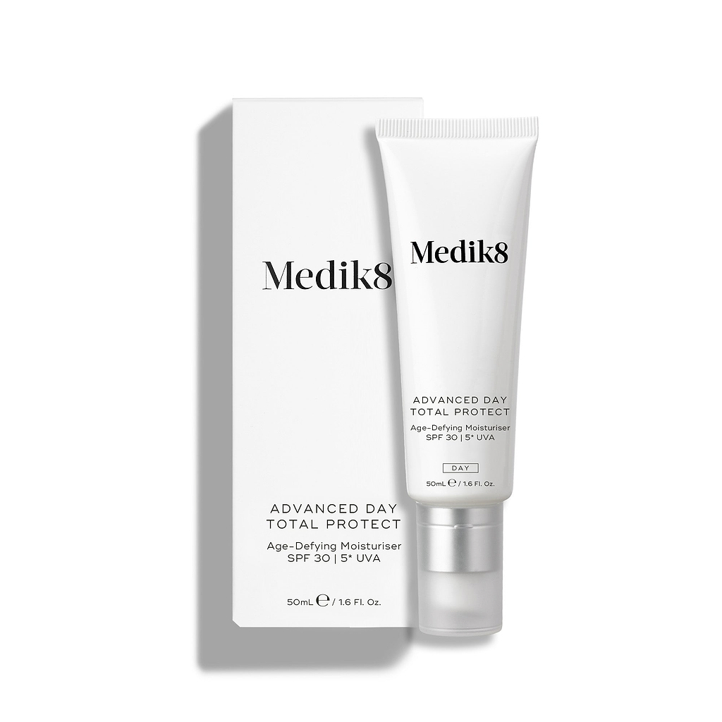 Medik8 Advanced Day Total Protect tube stands on a clean white background with a matching white outer carton. Text identifies the product as a 50mL Age-Defying Moisturiser with SPF 30 and 5* UVA protection.