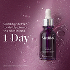 Medik8 Hydr8 B5 Intense glass dropper bottle centered on a shimmering purple background with translucent water droplets. Bold text states the product is clinically proven to visibly plump the skin in just 1 Day.