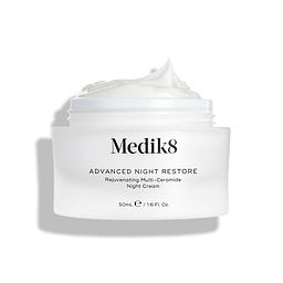 Medik8 Advanced Night Restore cream jar shown open with a rich dollop of white cream peaked on top against a clean white background, highlighting its smooth, restorative texture. Black text on the jar reads "Rejuvenating Multi-Ceramide Night Cream".
