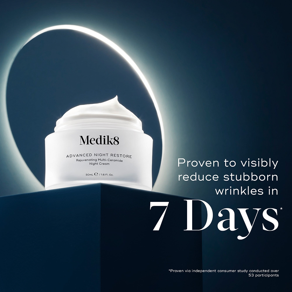 Medik8 Advanced Night Restore cream jar placed on a dark blue plinth with a glowing light ring behind it. Text highlights "Proven to visibly reduce stubborn wrinkles in 7 Days*" based on an independent consumer study.