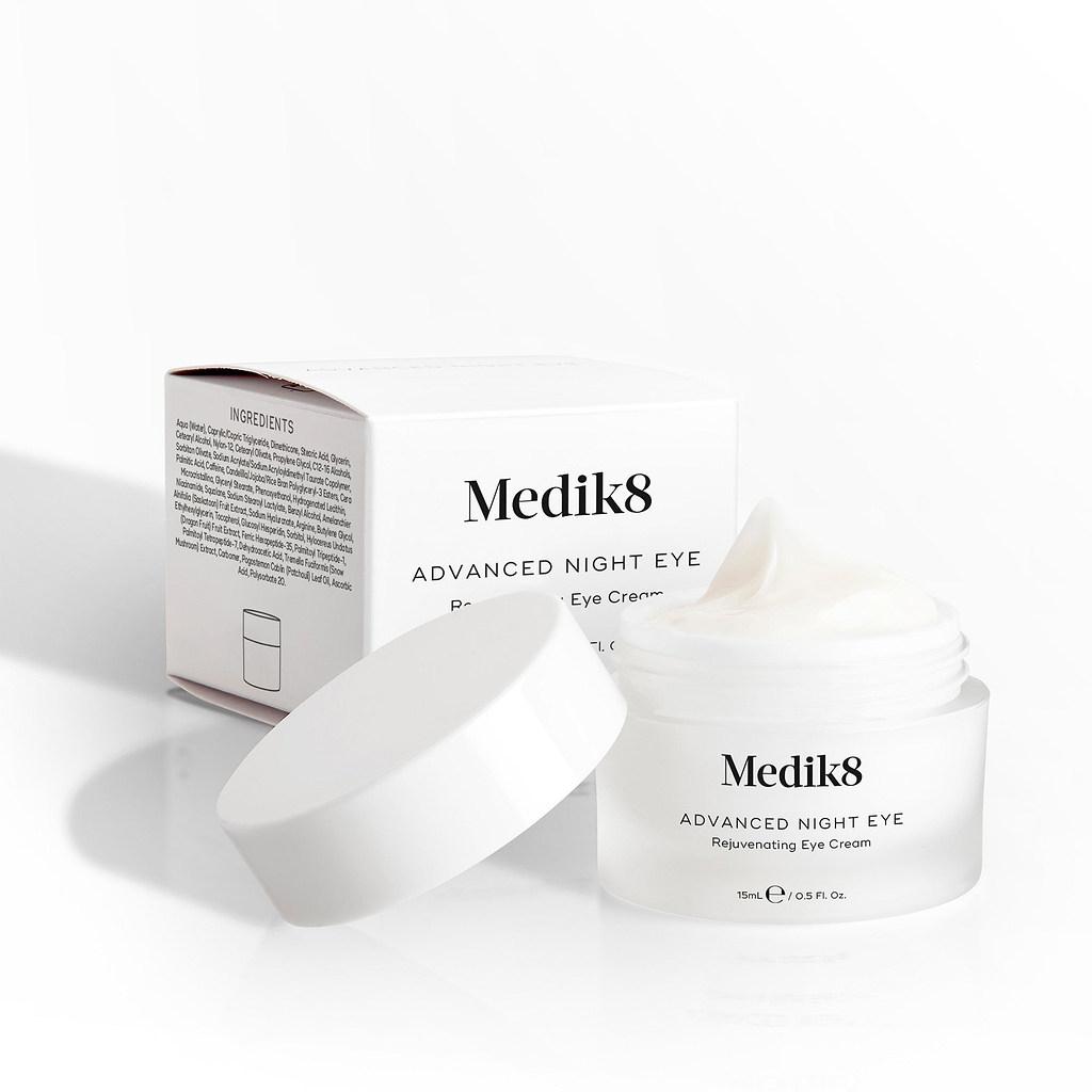 Medik8 Advanced Night Eye cream jar sits open next to its packaging box on a white background. Text highlights the "Rejuvenating Eye Cream" formula and 15mL size.