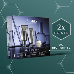 A square promotional banner set against a deep green background with subtle glowing hexagonal outlines. It features the Medik8 Nighttime Reset gift set box. A glowing white hexagon badge highlights "2x POINTS," with text below showing the points value increasing from 90 to 180.