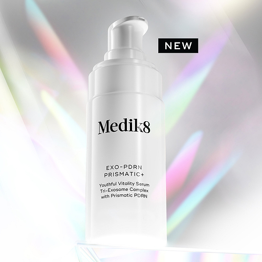 A white Medik8 Exo-PDRN Prismatic+ pump bottle resting on a clear prismatic surface against a light grey background with holographic, colourful light flares. A black badge reads "NEW". Text on the bottle details it as a "Youthful Vitality Serum Tri-Exosome Complex with Prismatic PDRN".