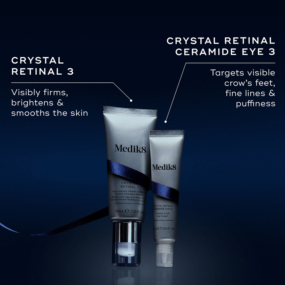 Two Medik8 products wrapped in a dark blue ribbon against a dark blue background, with text highlighting key benefits for each. The Crystal Retinal 3 tube "Visibly firms, brightens & smooths the skin," and the Crystal Retinal Ceramide Eye 3 tube "Targets visible crow's feet, fine lines & puffiness."