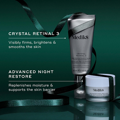 Two Medik8 products wrapped in a green ribbon against a dark green background, with text highlighting key benefits for each. The Crystal Retinal 3 tube "Visibly firms, brightens & smooths the skin," and the Advanced Night Restore travel size jar "Replenishes moisture & supports the skin barrier."