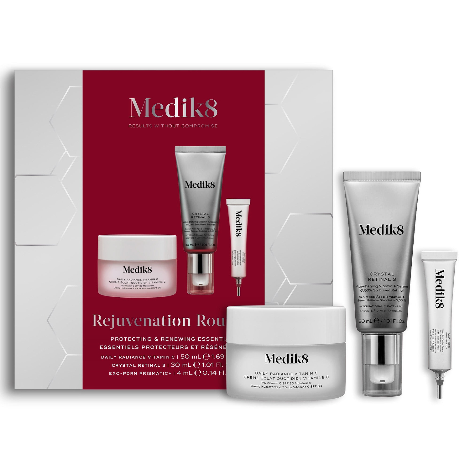 A Medik8 "Rejuvenation Routine" gift box displayed on a white background with a deep red center and hexagonal graphics, showing the printed products inside. A Daily Radiance Vitamin C jar, Crystal Retinal 3 tube, and Exo-PDRN Prismatic+ deluxe sample stand loose beside the box.