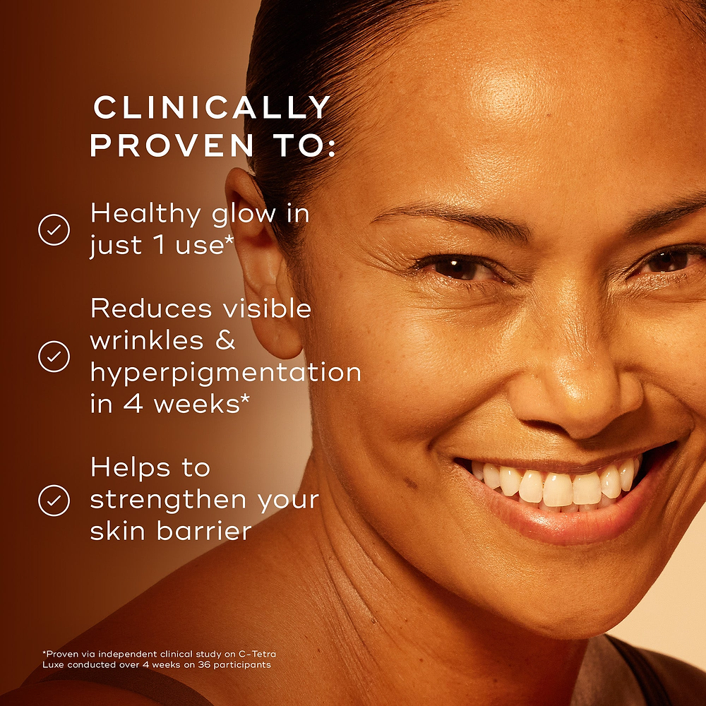 Close-up of a smiling woman with glowing skin on a warm orange background. Text reads: ‘Clinically proven to: Healthy glow in just 1 use*. Reduces visible wrinkles and hyperpigmentation in 4 weeks*. Helps to strengthen your skin barrier.’
