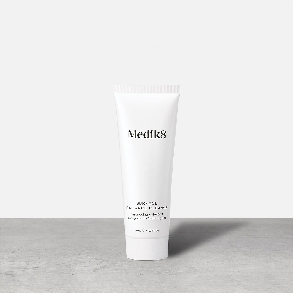 A single white tube of Medik8 Surface Radiance Cleanse stands on a grey surface. Label text includes: Medik8, SURFACE RADIANCE CLEANSE, Resurfacing AHA/BHA, Mangosteen Cleansing Gel, and 40mL℮ / 1.3 Fl. Oz.
