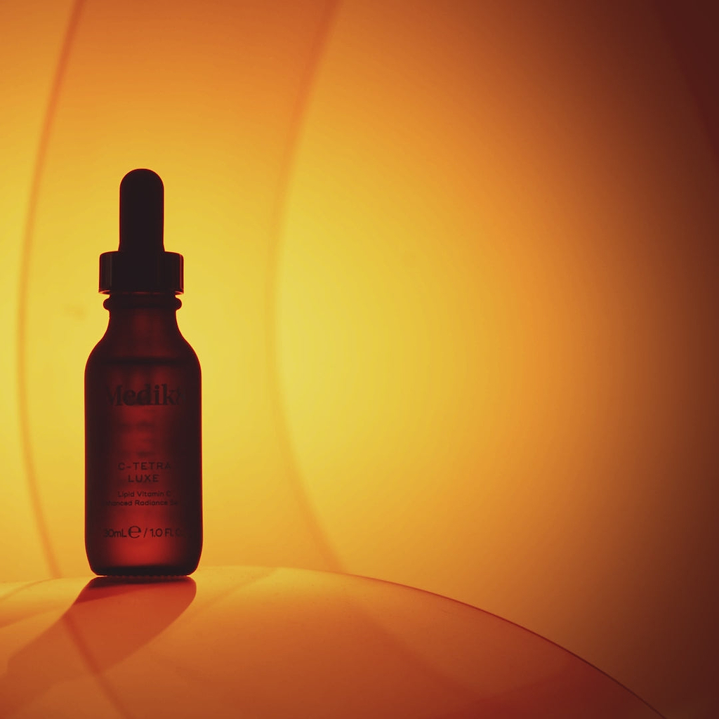 A video for Medik8 C-Tetra Luxe serum featuring an amber dropper bottle and a woman with glowing skin. Text highlights include "2x more Vitamin C than our original C-Tetra" and "14% Vitamin C in a nourishing oil." The video states it is clinically proven to instantly boost skin radiance, visibly reduce wrinkles, and reduce dark spots, with "86% agree it’s the best Vitamin C serum."